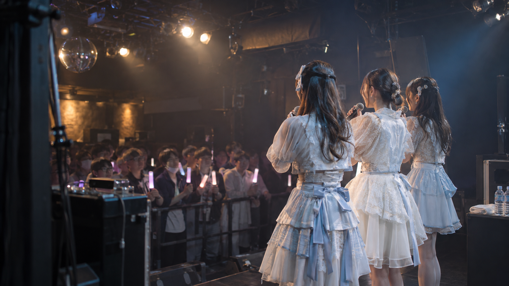初めてのライブ会場で観客に挨拶するアイドルたちのイメージ